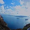 The view from Fira, Santorini's capital city on the Aegean Sea, includes an active volcanic island formed by the same volcano that formed the Santorini islands.