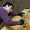Douglas Chilton uses traditional carving tools to shape the Raven Spirit canoe.