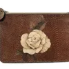 A brown clutch bag made from fish skin with a beige flower in the center, patterned with wood grain.