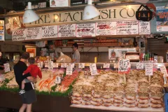 Seafood vendor at historic Pike Place Market in Seattle, Washington (USA). The market draws both shoppers and gawkers who come to watch the gregarious crew of fishmongers.