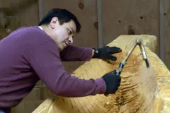 Douglas Chilton uses traditional carving tools to shape the Raven Spirit canoe.