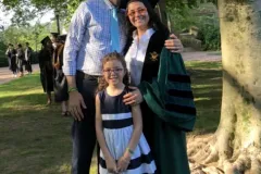 a young family of three celebrate the mother's graduation
