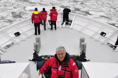 A photo of oceanographer Xavier Pastor aboard an Oceana research vessel surrounded by ice in the Baltic Sea