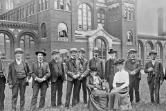 a group of men standing and two women sitting in front of the National Museum building