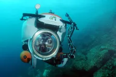 Marine researchers Carole Baldwin and Adrien Schrier wear santa hats in a submersible in the Caribbean.