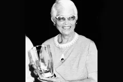 a black and white photo of a woman holding a glass award