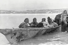 a group of inuit in a large skin boat
