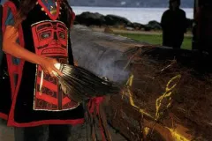 Elders bless a new canoe with lighted sage, song, and traditional dances.