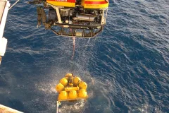 A remotely operated vehicle (ROV) recovers a volcano monitor from an underwater observatory.