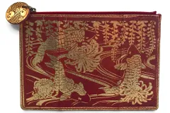 A bright red clutch bag made from fish leather and patterned with shimmering gold koi fish imagery.