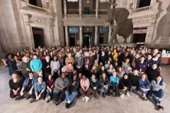 a group photo of many women in the rotunda with a stuffed bull elephant