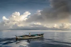 A Honduran small-scale fisherman on a boat setting out to fish. 