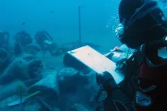 A researcher takes notes at the site of an ancient shipwreck recently discovered in Mazotas, Cyprus. The ship went down in the 4th century B.C. loaded with expensive and sought-after wine from Greece.