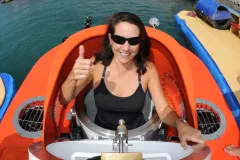 a woman getting in a submersible giving thumbs up 