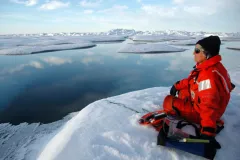 A marine mammal scientist listens for bowhead whales using an underwater hydrophone.