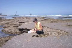 Woman on rock near ocean