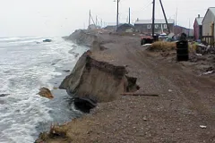 A stormy sea lashes the village of Shismaref, Alaska, where the coastline has eroded 30–90 m (100–300 ft) in the past 30 years.
