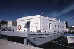 A small ship with a building on it  