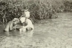 two people crouch in the water