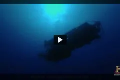 Screenshot from video "Deep Ocean Explorers" that shows view from below of submersible Alvin underwater.