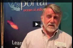 Screenshot from video showing Dennis Whigham in front of a banner talking about Phragmites.