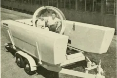 two people sit in a vehicle with an acrylic dome
