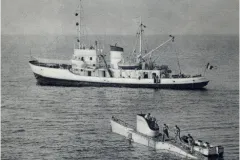 a submarine in the ocean next to its mother ship