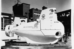 a small white submersible sits in a dry dock
