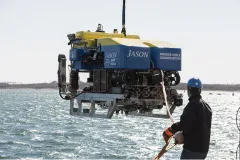 a person pulls in a blue and yellow ROV
