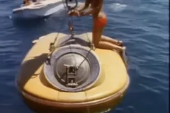 a yellow submersible with a person kneeling on top