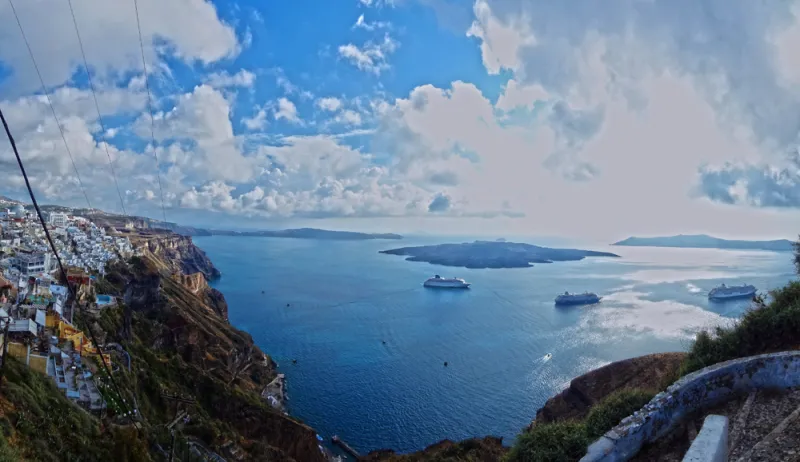The view from Fira, Santorini's capital city on the Aegean Sea, includes an active volcanic island formed by the same volcano that formed the Santorini islands.