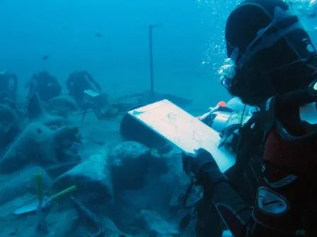 A researcher takes notes at the site of an ancient shipwreck recently discovered in Mazotas, Cyprus. The ship went down in the 4th century B.C. loaded with expensive and sought-after wine from Greece.