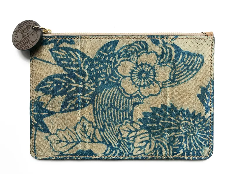 A clutch bag made from fish skin and decorated with blue floral patterns.