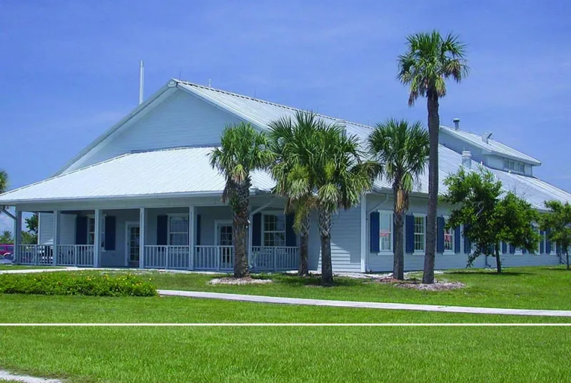 A gabled building alongside palm trees