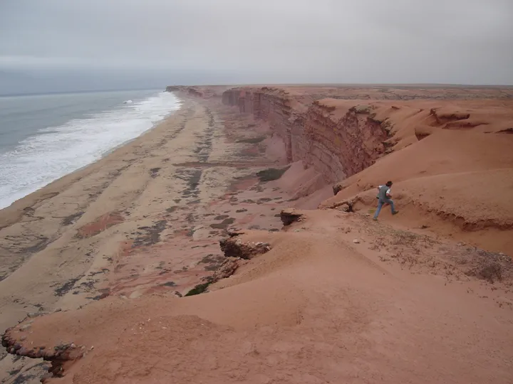 Sandy cliffs of coastal Angola with waves crossing on the shore. 