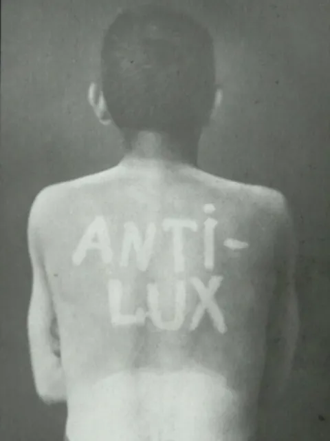 a man's back with words "antilux" written on it