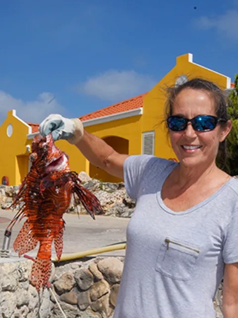 A woman holding a lionfish