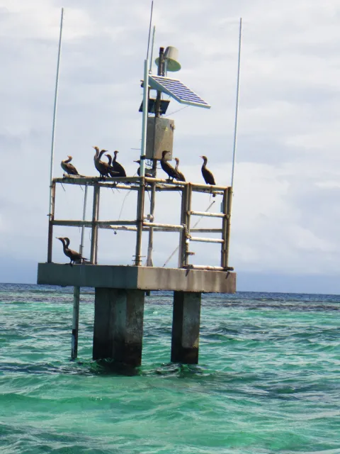 a concrete platform above the water with a weather station 