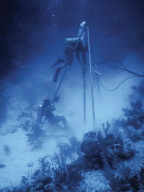 scuba divers work on an underwater drill site