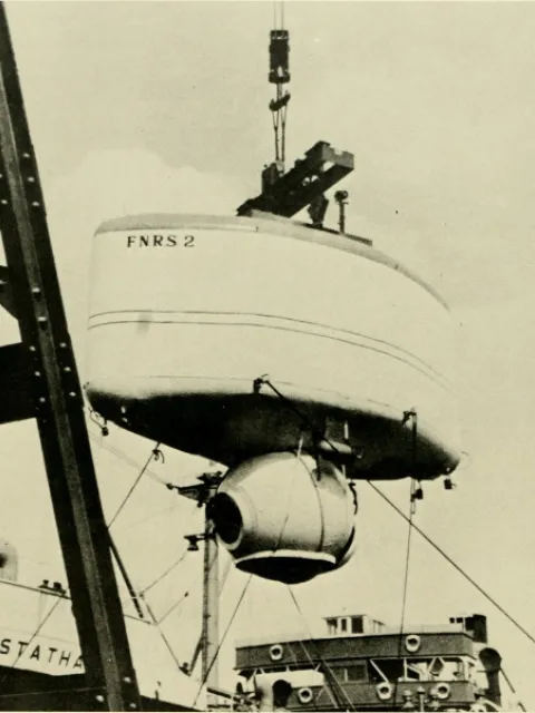 a white submersible hangs from a crane