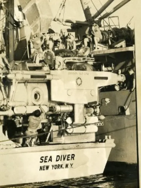 the back of a big boat with a submersible on the back